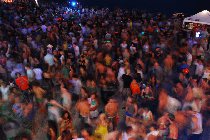 full moon party in Thailand with a huge crowd of people on a beach partying