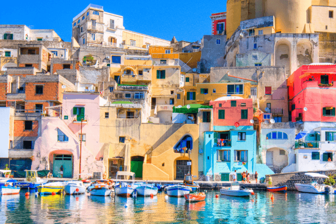 multi colour houses by the sea front in capri with boats in water