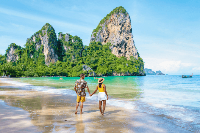 man and woman holding hands on beach in thailand