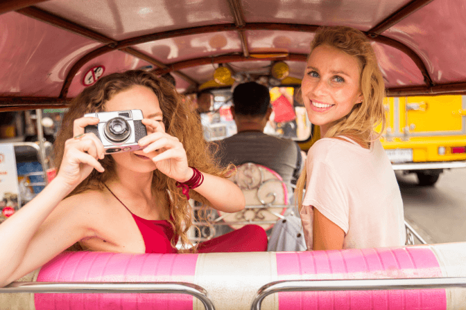 2 women in the back of a car taking a photo in bangkok